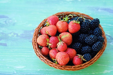Blackberries and strawberries from the garden on a wooden backgroundの写真素材