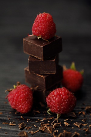 Delicious dark chocolate and ripe pink raspberriesの写真素材