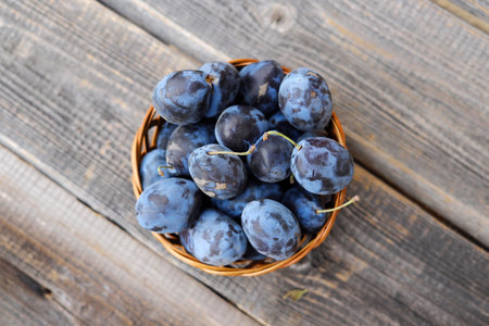 Delicious blue ripe plums in wooden basketの写真素材