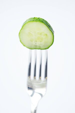 Fresh green cucumber on the fork for dietの写真素材