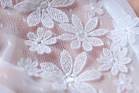 Beautiful delicate openwork white lace in handの写真素材