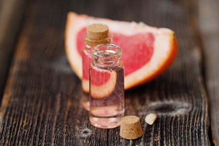 Pink grapefruit oil and fruit on the tableの写真素材