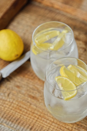 Fresh lemonade with ice and lemon on the tableの写真素材