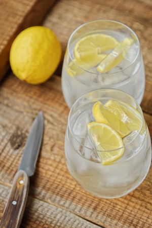 Fresh lemonade with ice and lemon on the tableの写真素材