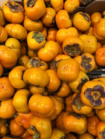 Delicious ripe orange persimmon on the marketの写真素材
