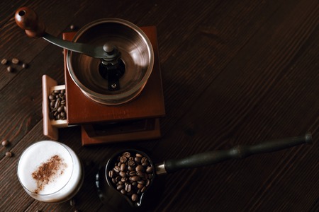 Roasted coffee beans in a copper Turk and coffee grinderの写真素材