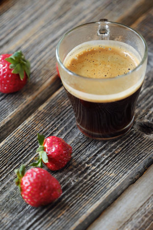 Fresh Americano coffee and strawberries on the tableの写真素材
