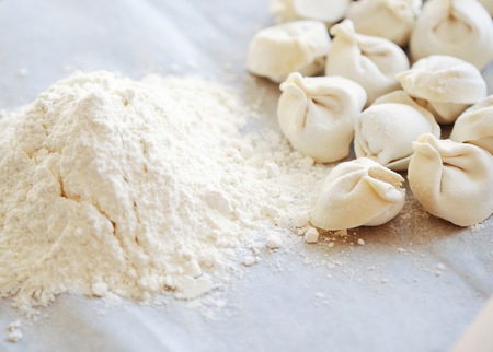 Homemade dumplings and flour on the tableの写真素材