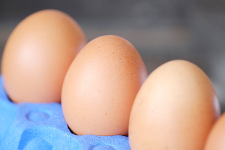 Chicken eggs in the purple package on the table