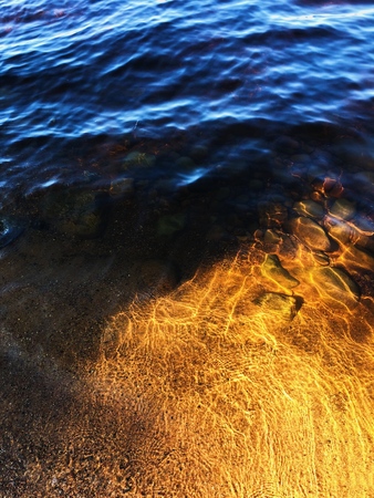 Beautiful view of Golden sand and stones under waterの写真素材