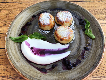 Delicious cheesecakes with mint sour cream and blueberry jamの写真素材