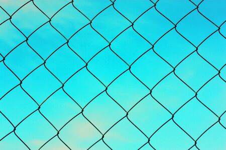 Black metal mesh on the background and blue skyの写真素材