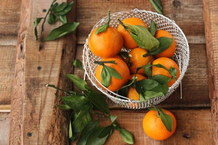 Juicy fresh tangerines with leaves on the tableの写真素材
