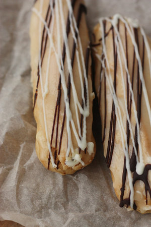 Delicious eclairs with vanilla and chocolate cream