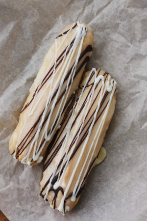 Delicious eclairs with vanilla and chocolate cream
