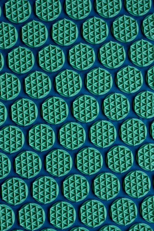 Seamless pattern of green and blue plastic perforated holes