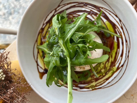 Fresh arugula salad with mushrooms in a bowl on the table