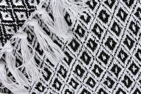 Texture, background, pattern. The fabric is black and white. Knitted woolen shawl with a pattern of...