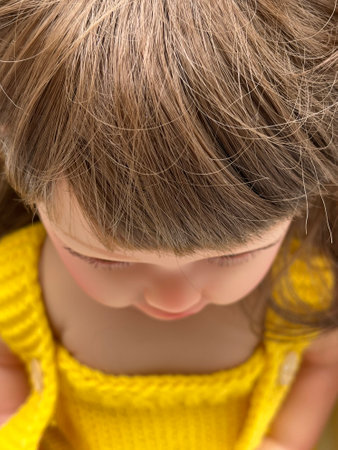 Little doll in a yellow knitted sweater. Close-up.の写真素材