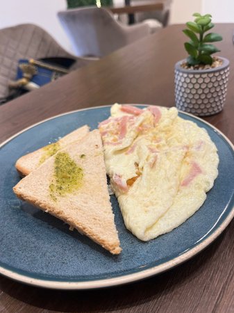 Omelet with ham and cheese on blue plate, Japanese food