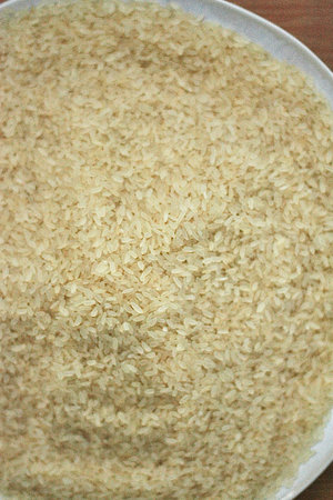 Rice in a bowl on wooden background. Close up. Selective focus.の写真素材