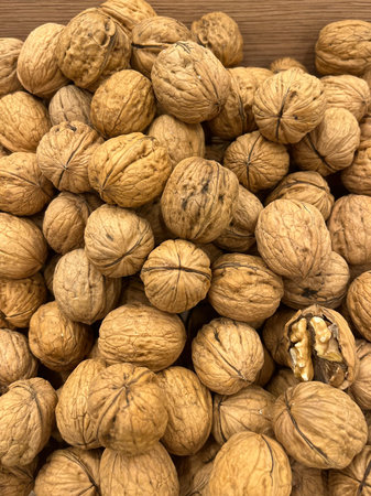 Heap of walnuts on wooden background, close-up.