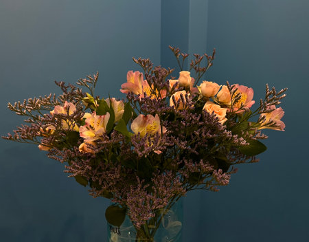 Bouquet of flowers in a vase on a blue backgroundの写真素材