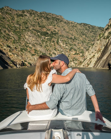 Young couple on a yacht holding two glasses of wineの写真素材