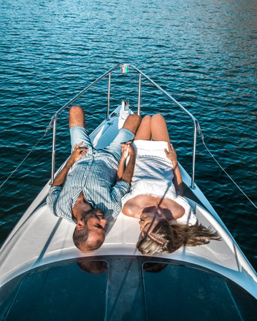 Young couple on a honeymoon on a yacht holding handsの写真素材