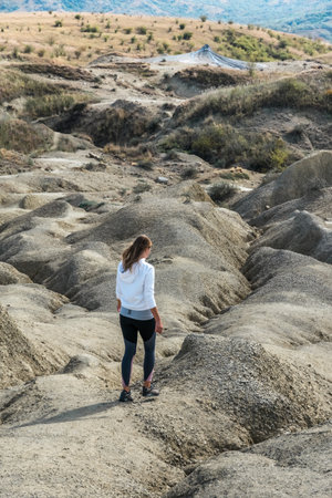 Young girl exercising outdoors and wearing sportswear, picture taken in the mud volcanoes park in Romaniaの写真素材