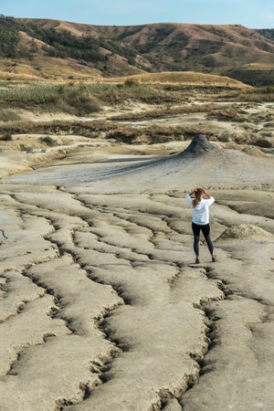 Young girl exercising outdoors and wearing sportswear, picture taken in the mud volcanoes park in Romaniaの写真素材