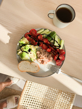 Healthy lunch with fresh salad, bread, and coffee served on a wooden table