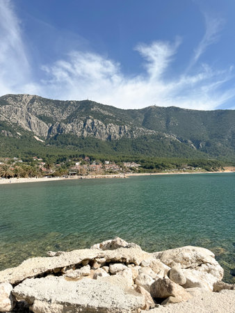 Stunning coastal view of mountains and clear water under a blue sky during the dayの写真素材