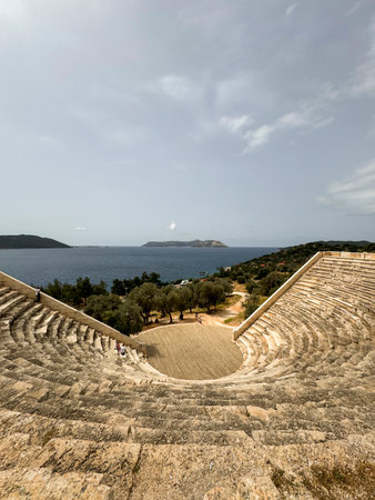 Ancient amphitheater with ocean view near olive trees on a sunny dayの写真素材
