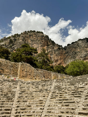Ancient theater nestled between mountains under a bright sky