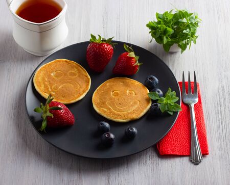 Pancakes on wooden table with berries