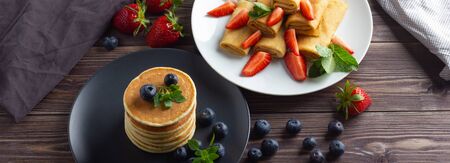 Pancakes with berries on brown wooden backgroundの写真素材