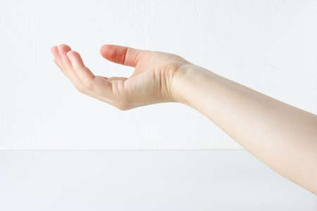 Womans hand outstretched, woman lends a helping hand or need help. Charity concept. White background.の写真素材