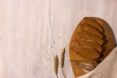 Slices of fresh homemade organic bread on wooden board with whole grain. Top view with copy space.の写真素材