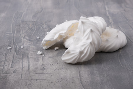 Broken meringues with crumbs on gray background. Close up.の写真素材