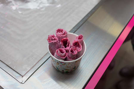 He puts marmalade sweets in ice cream rolls.macro closeup