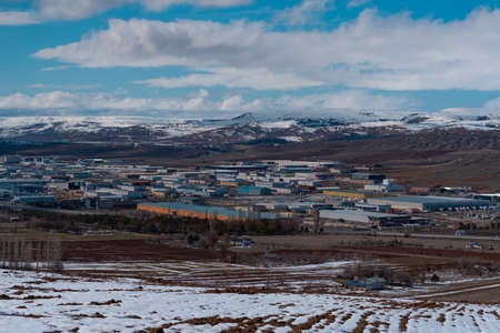 Panorama of an industrial plant in the mountains in winter. Working materials containers are located in the middle of natural surroundings.の写真素材