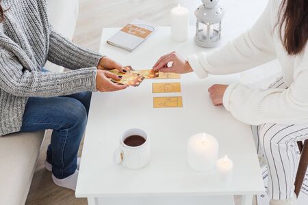 Two girls are sitting at a table drinking hot tea