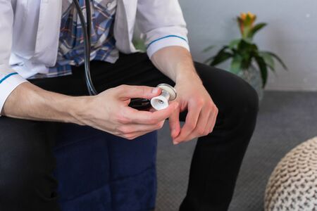 Doctor holding stethoscope in his hand wearing medical gown, ready to examine a patient. Close Upの写真素材