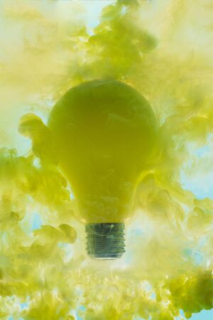 Concept idea. Light bulb levitates in a yellow haze.の写真素材