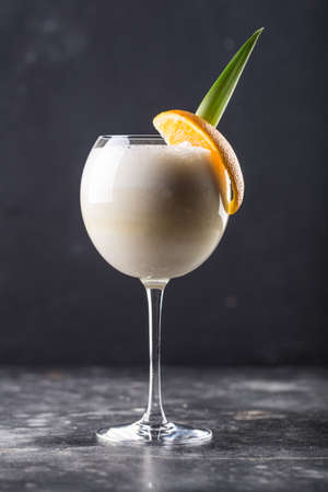 Refreshing alcohol cocktail pina colada in glass placed on table. High quality photo