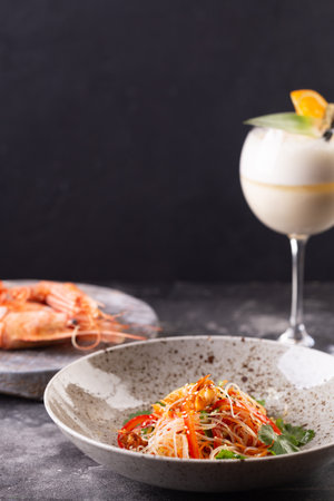 Funchose salad with shrimps and vegetables with sesame seeds and cocktail glass. Photo for menuの写真素材