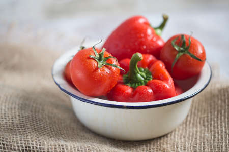 Fresh red Peppers And Tomatoes in white metal Bowl healthyの写真素材