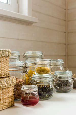Assortment of uncooked grains, cereals and pasta in glass jars on wooden table. Healthy cooking, clean eating, zero waste concept.の写真素材