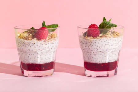 Chia seeds vanilla pudding with raspberry, oats musli and mint on rose hard shadowの写真素材